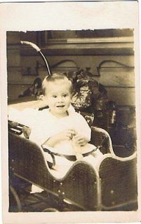 postcard 942429 rppc baby in buggy playing with toy doll