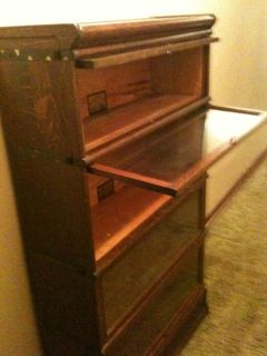 Oak and mahogany bookcases with glass front doors which lift up and 