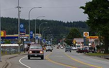 Photo of a three lane main street in a small town. Visible is a